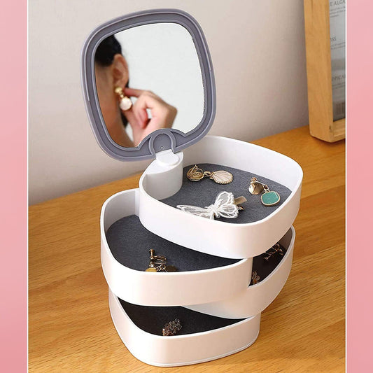 Rotating jewellery box open with mirror and earrings in the layers