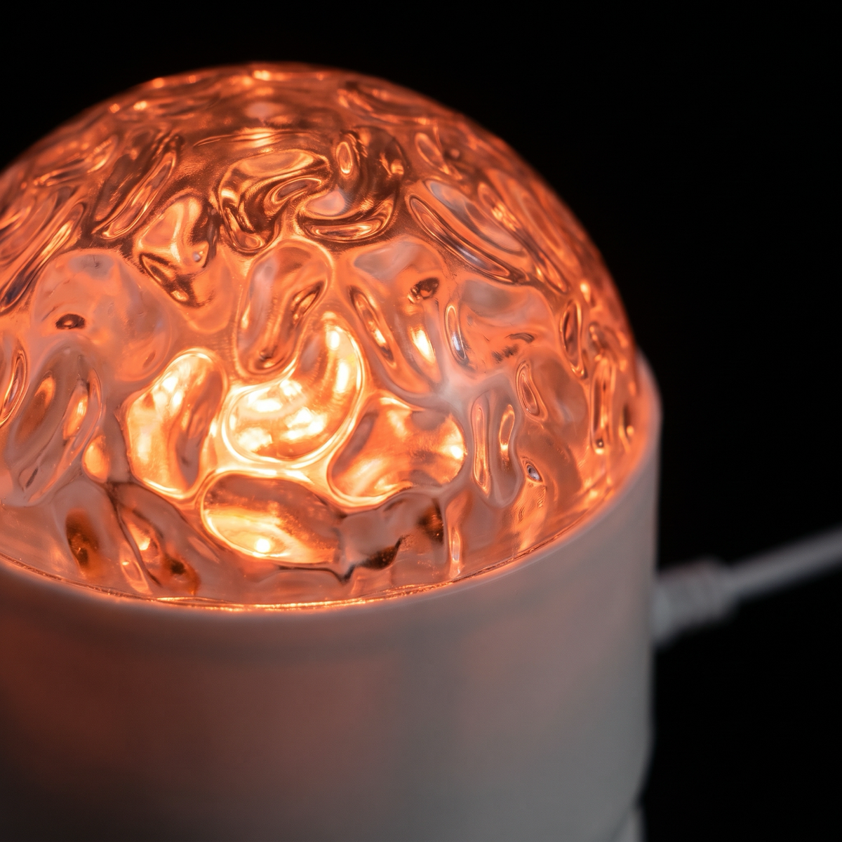 Rippled dome lens of the projector glowing orange