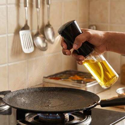 Spraying a thin layer of oil on a tawa in an Indian kitchen