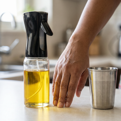 Oil sprayer size next to a chai glass and hand